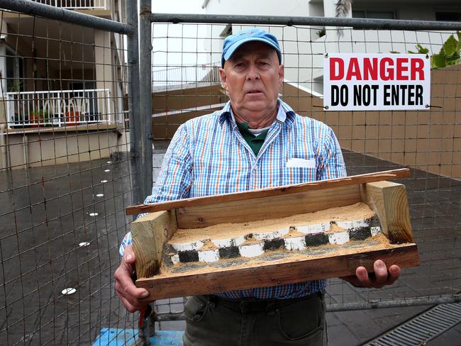 Keith Muller with his concept model in front of evacuated properties at Wamberal. Picture: Toby Zerna