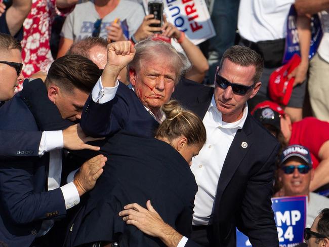 The female Secret Service agent, bottom, is seen helping Donald Trump off the stage in Butler, Pennsylvania, after the attempt on his life. Picture: AFP