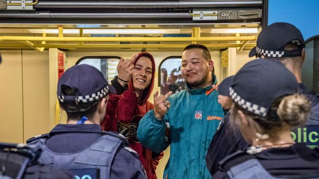 Young men show disrespect to police after they are ushered onto a train. Picture: Jason Edwards