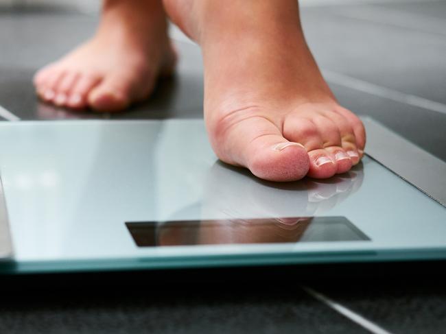 Female bare feet with weight scale in the bathroom, scales generic