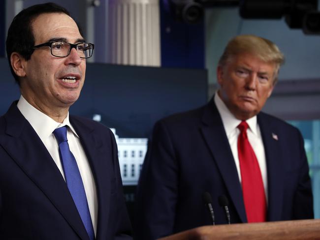 Donald Trump listens as Treasury Secretary Steven Mnuchin speaks about the coronavirus. Picture: AP.