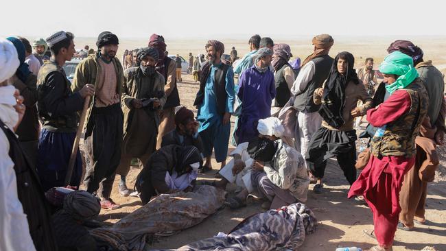 Afghan mourners sit beside their relatives' bodies from the earthquakes in Sarbuland village, Zendeh Jan district of Herat province on Sunday. Picture: AFP