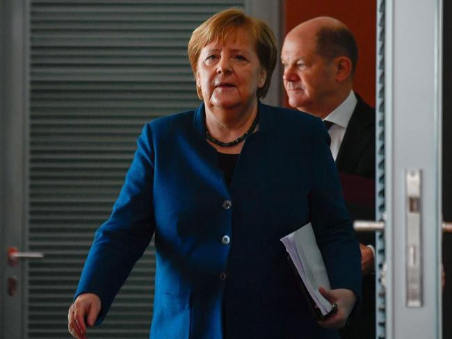 Then German chancellor Angela Merkel enters the cabinet room followed by then finance minister and vice-chancellor Olaf Scholz in 2020. Picture: AFP