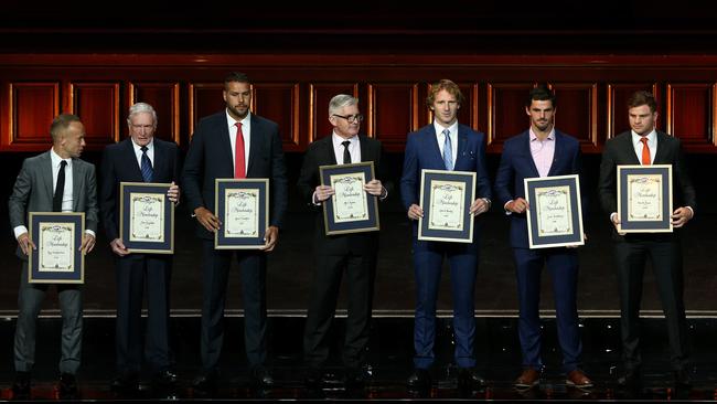 AFL Life Members inducted this year (from left) umpire Ray Chamberlain, John Dugdale, Lance Franklin, Merv Keane, David Mundy, Scott Pendlebury and Heath Shaw on stage during the 2019 AFL season launch at Melbourne Town Hall in March. Picture: AAP Image/Hamish Blair