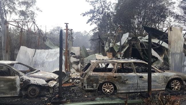 Burned-out vehicles outside a home destroyed at Dondingalong near Kempsey. Picture: Frank Redward
