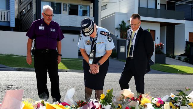 Ms Carroll pictured looking at flowers left for Hannah Clarke and her children. Picture AAP/David Clark