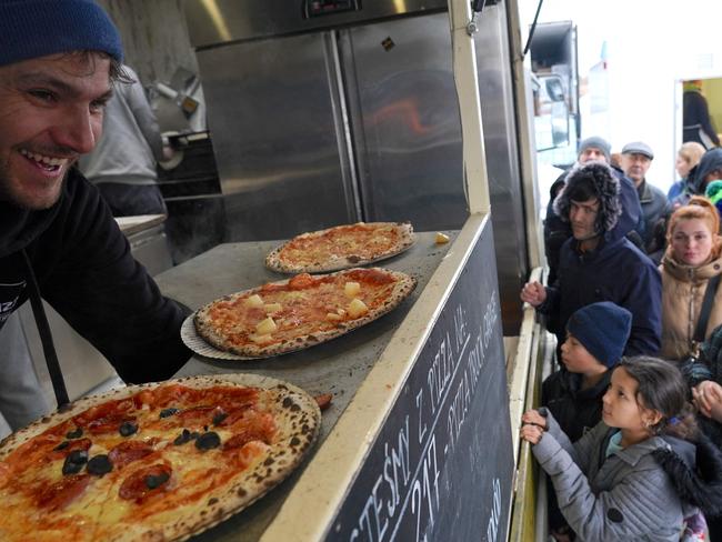 An owner of a food truck distributes free pizzas to Ukrainian refugees at the refugee distribution centre in Korczowa, Poland. Picture: Janek Skarzynski / AFP