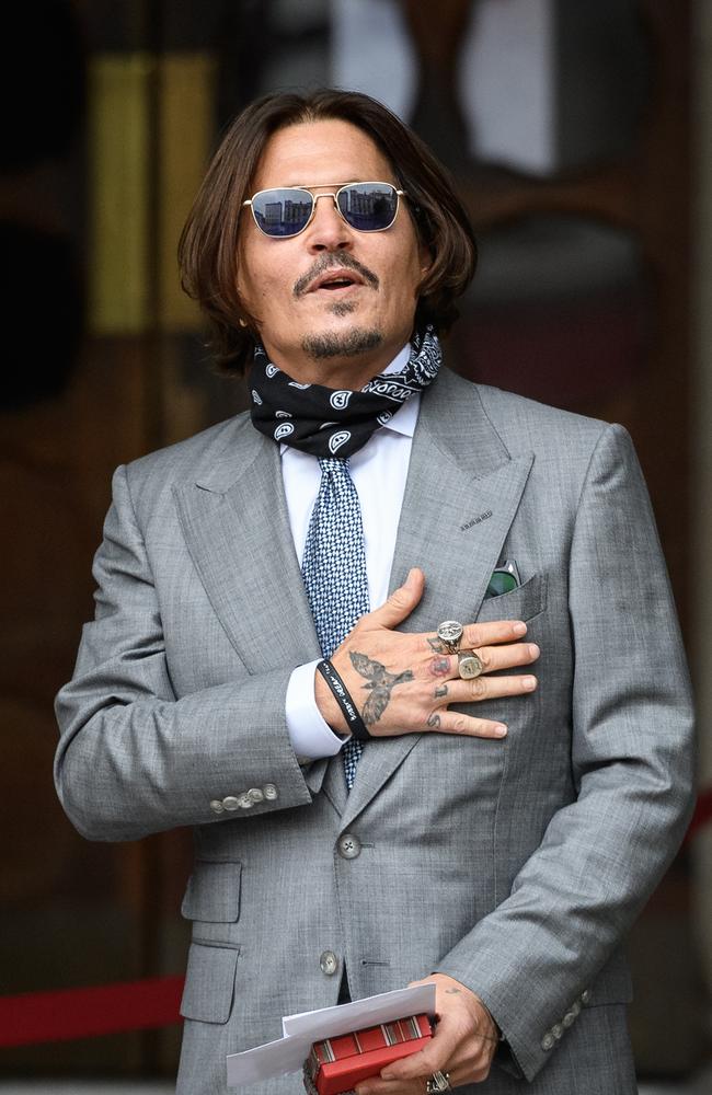 Johnny Depp clutches gifts and cards from wellwishers as he arrives at London’s Royal Courts of Justice. Picture: Getty Images