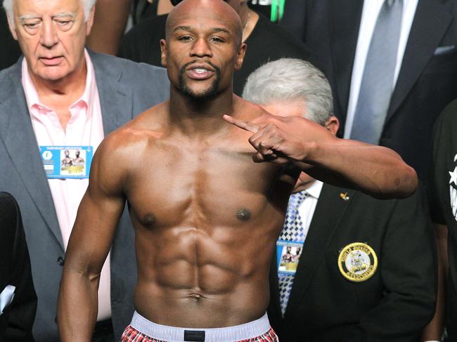 Floyd Mayweather Jr. gestures during his weigh-in with Andre Berto on September 11, 2015 at the MGM Grand in Las Vegas. Mayweather will defend his WBC/WBA welterweight titles against Andre Berto on September, 12 at the MGM Grand in Las Vegas. AFP PHOTO/ John Gurzinski