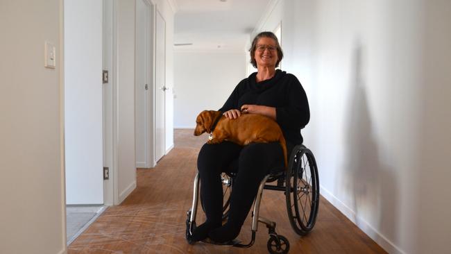 Asti Savage and her dog Jag show off a Elliot Springs home built to NDIS 'high physical support' spec - designed for those in power chairs.