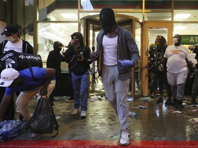 Protesters exit a 7-Eleven store in Chicago during protests over the death of George Floyd. Picture: John J. Kim/Chicago Tribune via AP