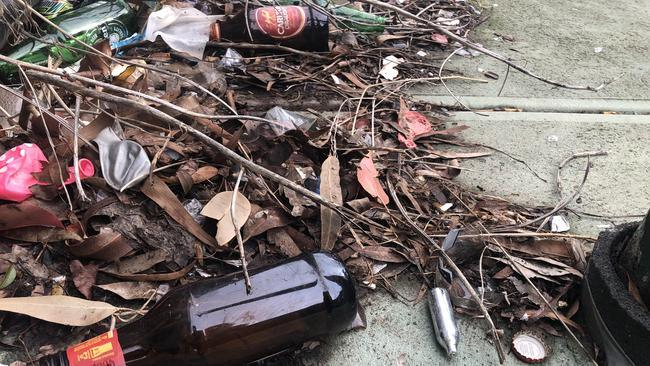 Empty beer bottles, cigarettes and nitrous oxide canisters line the pavement of the Moresby Court shopping strip.