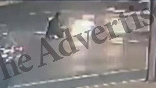 CCTV shows the woman seated in the middle of the road.