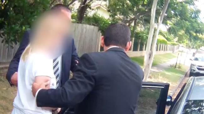 Maree Mavis Crabtree (face blurred) is led away by Gold Coast detectives after being charged with the murder of her two children.