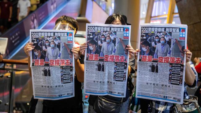 Jimmy Lai supporters hold up copies of the Apple Daily as they protest for press freedom inside a mall in Hong Kong on August 11. Picture: AFP