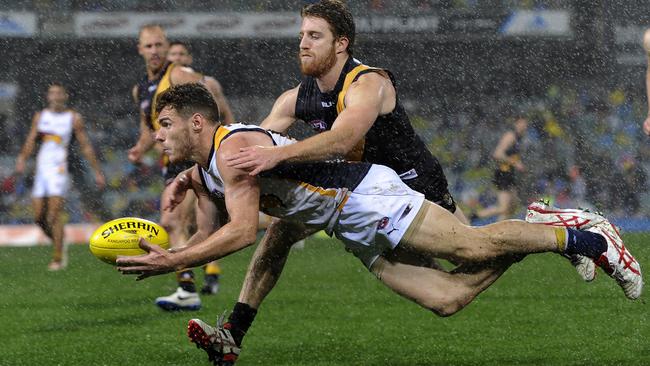 Eagle Luke Shuey dishes off a handball under pressure from Reece Conca. Picture: Daniel Wilkins