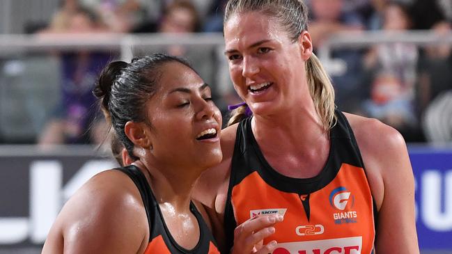 Giants players Kristiana Manu'a (left) and Caitlin Bassett celebrate a win early in the Super Netball season.