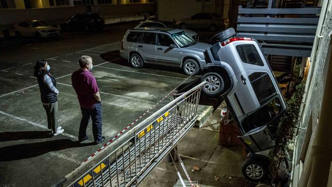 Residents inspect the four-wheel-drive’s precarious position. Picture: Jake Nowakowski