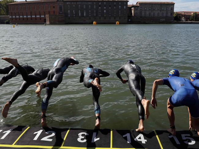 Triathletes dive into the Garonne river as they compete in the men's Supertri triathlon in Toulouse, south-western France, on October 6, 2024. (Photo by Valentine CHAPUIS / AFP)