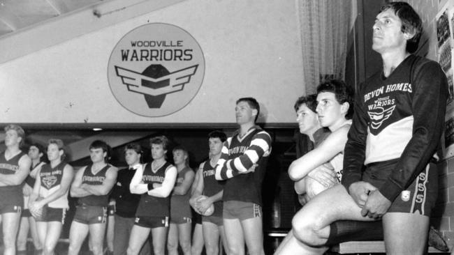 Woodville coach Russell Ebert (front) and footballers in club rooms listening to announcement of intended merger with West Torrens in 1990.