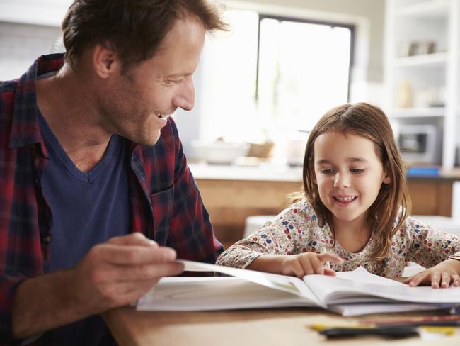 A father homeschooling his young daughter.