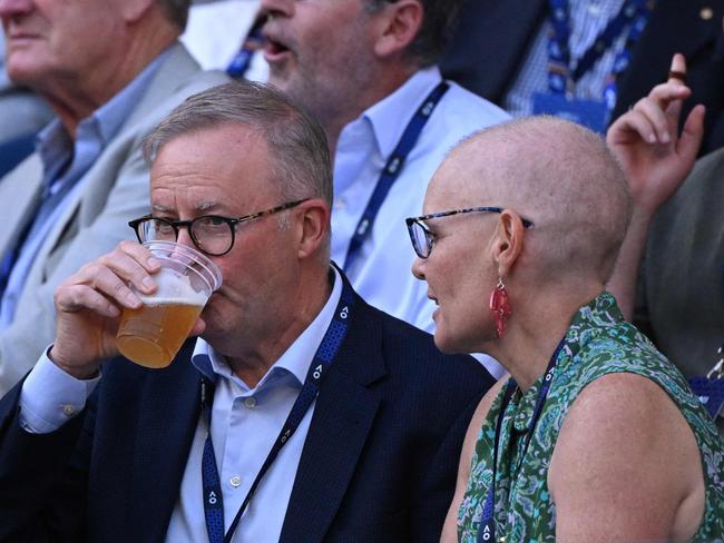 Australian Prime Minister Anthony Albanese (C) drinks as he watches the men's singles semi-final match between Serbia's Novak Djokovic and Tommy Paul of the US on day twelve of the Australian Open tennis tournament in Melbourne on January 27, 2023. (Photo by WILLIAM WEST / AFP) / -- IMAGE RESTRICTED TO EDITORIAL USE - STRICTLY NO COMMERCIAL USE --