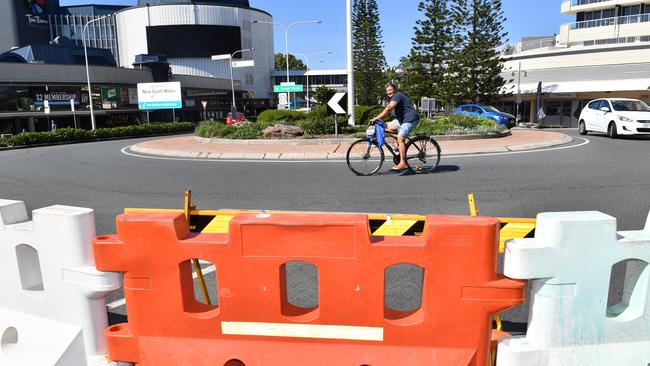 A cyclist is seen riding past a barrier across the Queensland and New South Wales border in Coolangatta. The border closure came into force at midnight April 3, 2020. (AAP Image/Darren England) NO ARCHIVING