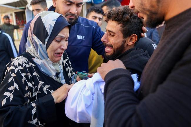 A woman cries over a two-year-old child killed in an Israeli strike in Gaza Thursday