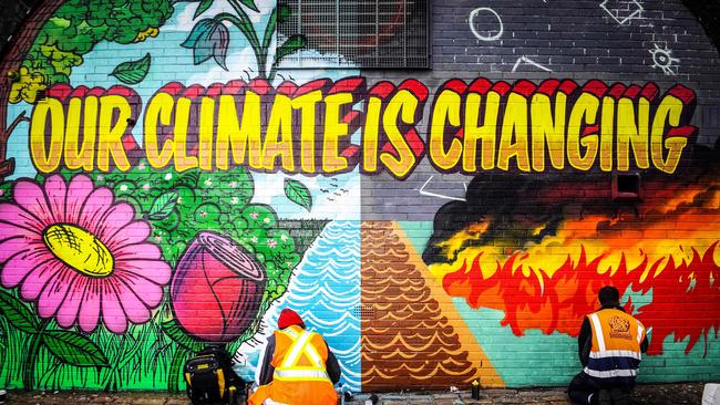 Street artists paint a mural on a wall opposite the COP26 climate summit venue in Glasgow. Picture: AFP