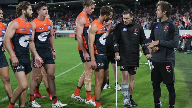 CANBERRA, AUSTRALIA - APRIL 04: Giants players talk to injured captain StephenÃÂ Coniglio of the Giants after losing the round 3 AFL match between the GWS Giants and the Melbourne Demons at Manuka Oval on April 04, 2021 in Canberra, Australia. (Photo by Cameron Spencer/Getty Images)