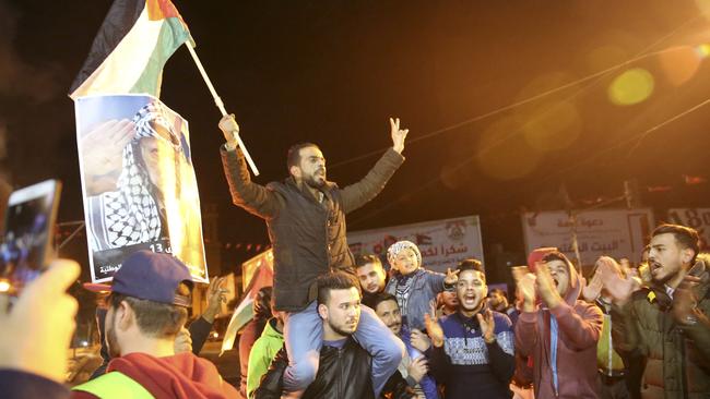 Palestinian protesters chant slogans as they wave their national flags and pictures of late Palestinian president Yasser Arafat during a protest at the main Square in Gaza City. (Pic: Adel Hana)