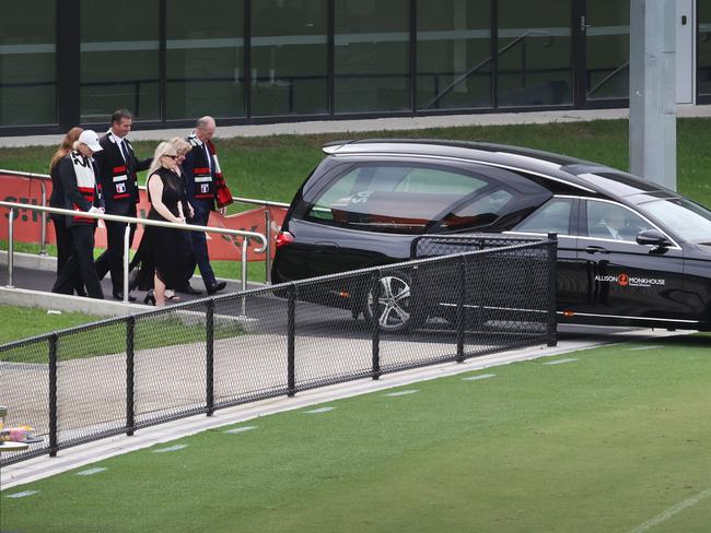 Family and friends follow the hearse for a lap of the ground. Picture: David Caird