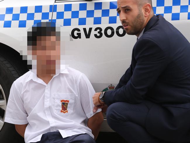 Police arrest the student outside an Aldi store near the high school. Picture: John Grainger