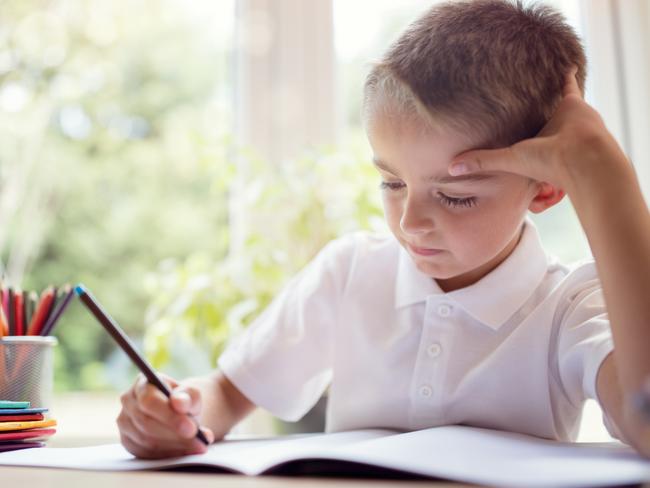 Quest - Schools of excellence - August 2018Boy writing in a notepad doing his school work or homework