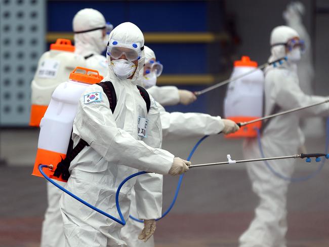 South Korean soldiers wearing protective gear spray disinfectant as part of preventive measures against the spread of the COVID-19 coronavirus.