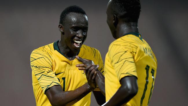 Thomas Deng (left) celebrates a goal with Socceroos teammate Awer Mabil.