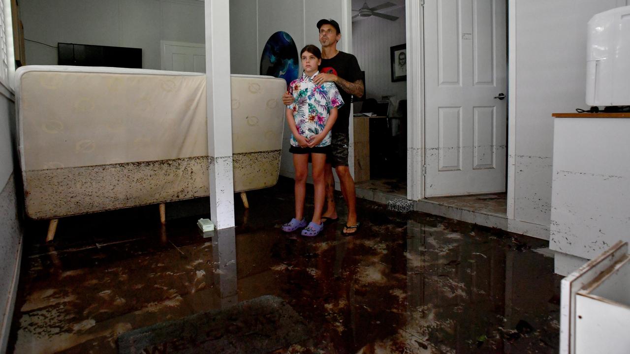 Bluewater residents Anthony Waugh, with daughter Nyah, 9, at the ground floor of their Forrestry Road home inundated by a fast rising Bluewater Creek. Picture: Evan Morgan