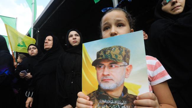 A girl holds a poster of Ibrahim Aqil, the head of Hezbollah's elite Radwan Force who was killed in an Israeli strike, during his funeral procession in Beirut's southern suburbs. Picture: AFP