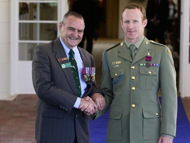 Warrant Officer Class II Keith Payne, who received his Victoria Cross in 1969, shakes hands with Mark Donaldson on the day he was awarded his VC at Government House in Canberra.