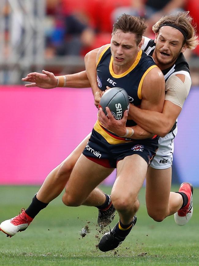 Crow Jake Kelly is wrapped up by Collingwood’s James Aish. Picture: Michael Willson/AFL Media/Getty Images