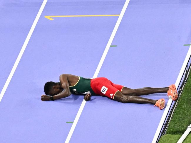 Ethiopia's Lamecha Girma lies on the track during the men's 3000m steeplechase final of the athletics event at the Paris 2024 Olympic Games at Stade de France in Saint-Denis, north of Paris, on August 7, 2024. (Photo by Ben STANSALL / AFP)