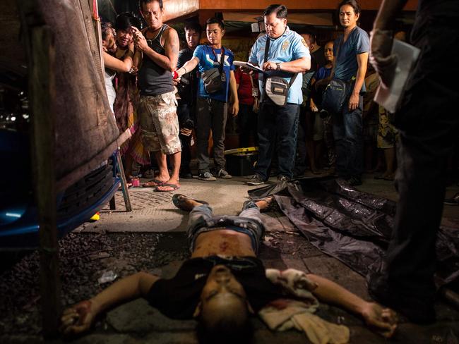 Family members grieve near the dead body of an alleged drug dealer in Manila on September 25, 2016. Picture: Noel Celis