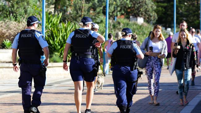 Police walk the esplanade at Coogee Beach. Picture: Gaye Gerard