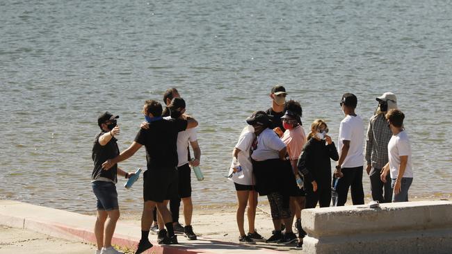 Cast members from the TV Show Glee and friends comfort each other as they gathered on Lake Piru. Picture: Getty.