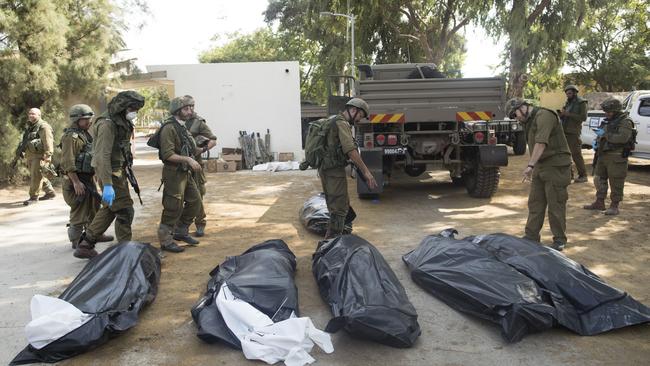 Israeli soldiers remove the bodies of civilians, who were killed days earlier in an attack by Palestinian militants on this kibbutz near the border with Gaza, on October 10. Picture: Getty