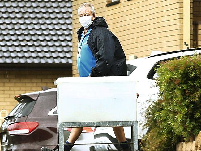 A masked service worker moves between buildings inside the Baptist Care Macquarie Park complex  which contains the Dorothy Henderson Lodge, where cases of the Covid-19 Corona Virus have been detected. Picture: John Appleyard