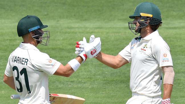 Joe Burns (right) of Australia celebrates his half century with David Warner during day two of the first Test Match between Australia and Pakistan at the Gabba. Picture: AAP