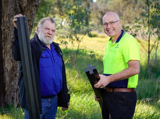 Tumbarumba farmer Steve McKay had to rebuild after the Black Summer fires. Plastic Forests Managing Director David Hodge is pictured with Mr McKay installing the soft plastic fence posts that were made possible by a Coles Nurture Fund grant. Picture: Supplied.