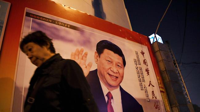 A woman walks past a roadside poster of Chinese President Xi Jinping. Picture: AFP