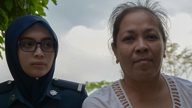 Australian national Maria Elvira Pinto Exposto is escorted by a Malaysian custom official as she arrives at the Magistrate Court in Sepang on April 30, 2015.